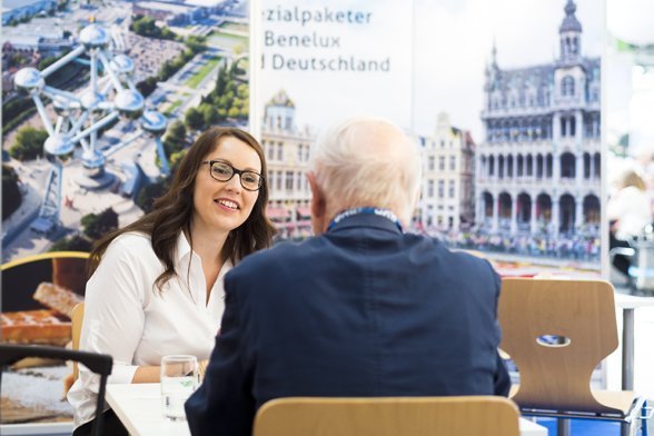 überland Tecklenburg auf der RDA in Köln – Beratungsgespräch mit Benelux-Motiven im Hintergrund