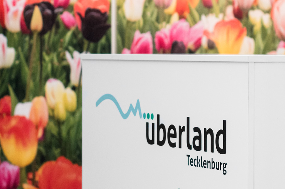 überland Tecklenburg Logo und Tulpenmotiv im Hintergrund
